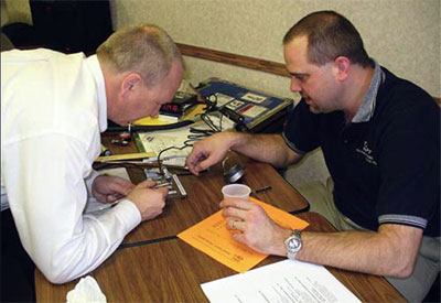 Glenn measures handpiece speed under the watchful eye of a Midwest trainer.