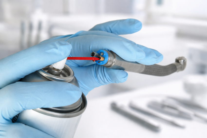 A dental professional performing high-speed handpiece maintenance to maintain performance and durability.
